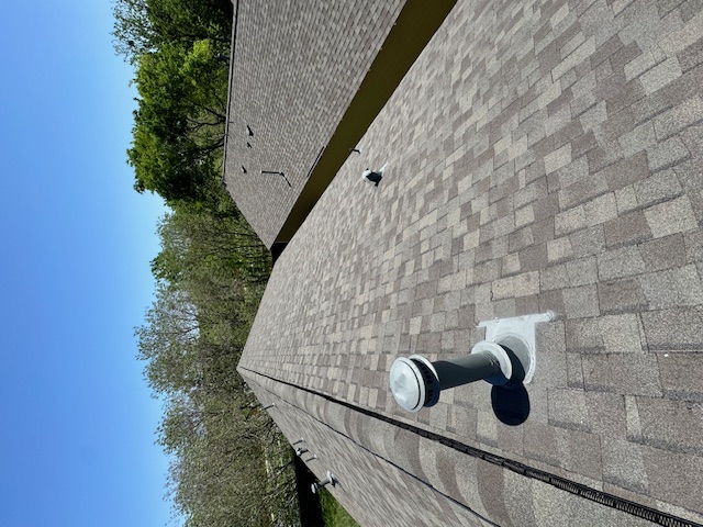 Crew installing shingles at roof edge